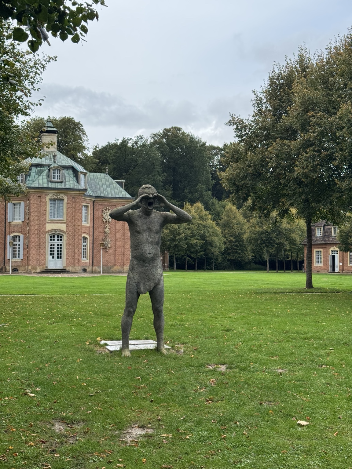 Beeld dat een toeter van zijn handen maakt om te roepen bij Schloss Clemenswerth